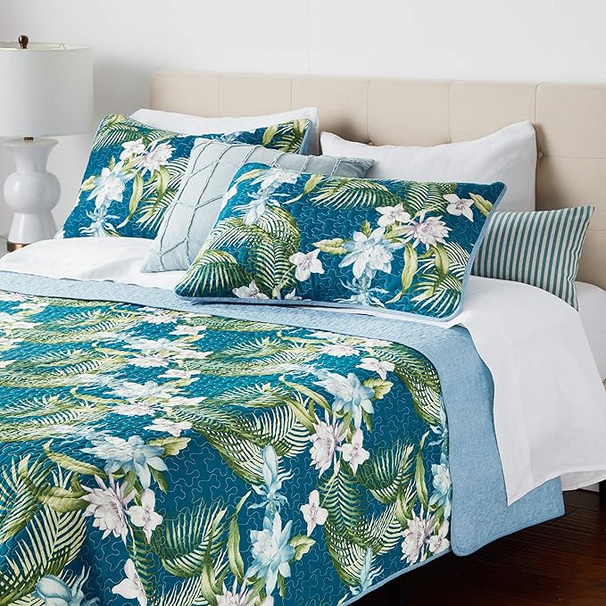 Bed with floral bedding and pillows in a bedroom setting