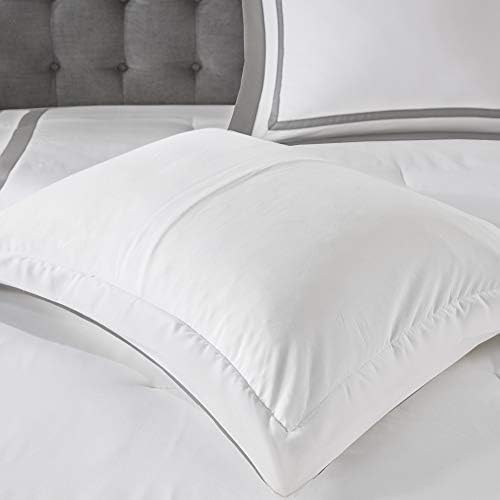 White comforter on a bed with gray headboard