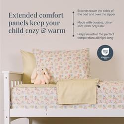 Crib with floral bedding and a stuffed animal, featuring text about comfort panels.