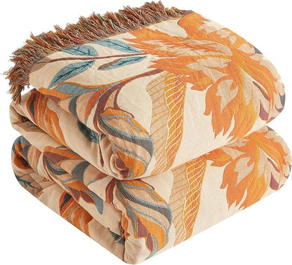 Folded floral-patterned blanket with orange, beige, and brown colors on a white background