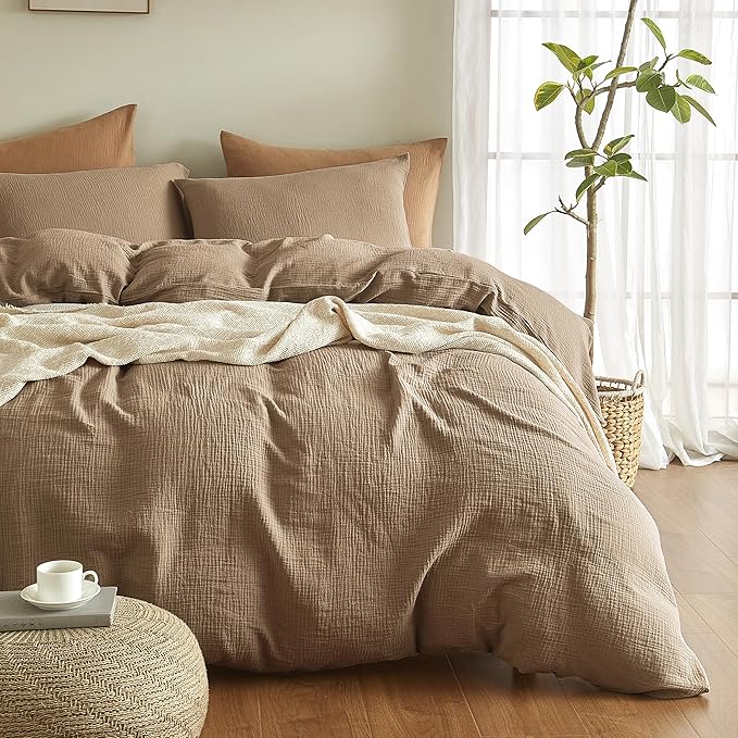 Beige textured duvet cover set on a bed with pillows and a plant in the background.