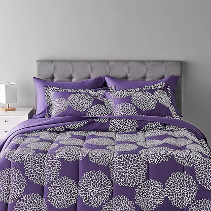 Purple floral patterned bedding set on a bed with a gray headboard.