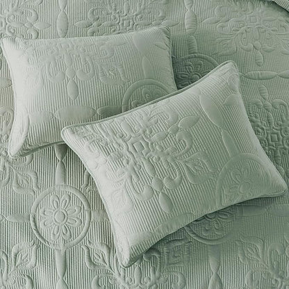 Two textured green pillows on a matching fabric background