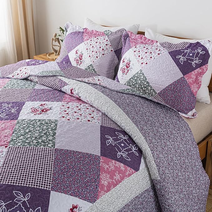 Patchwork quilt with floral and geometric patterns on a bed.