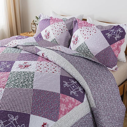 Patchwork quilt with floral and geometric patterns on a bed.
