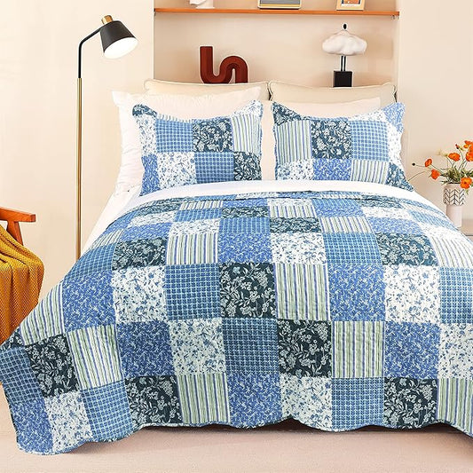 Bed with blue patchwork quilt and pillows in a bedroom setting.