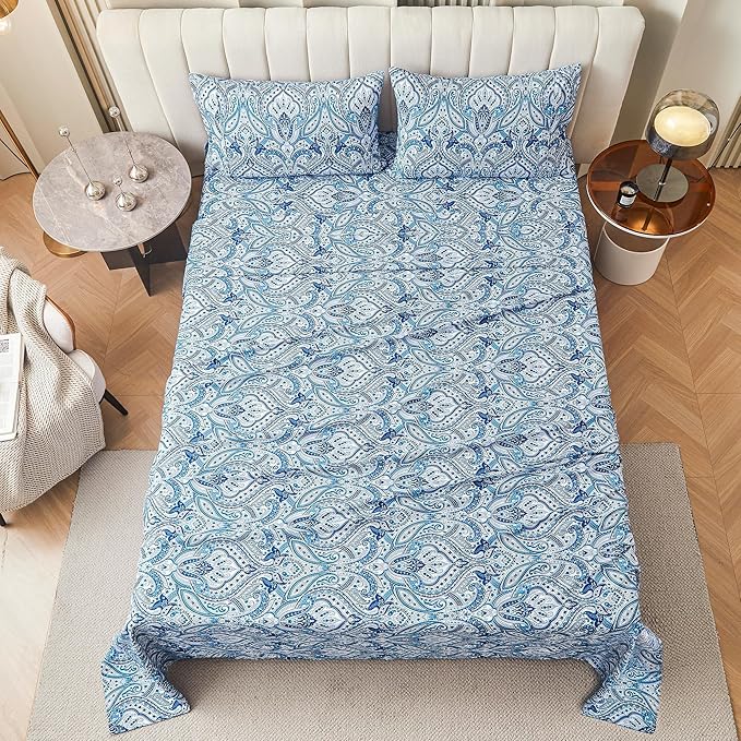 Blue patterned bedding set on a bed in a bedroom with side tables.