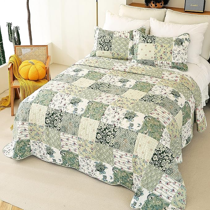 Patchwork quilt with floral patterns on a bed in a bedroom setting.