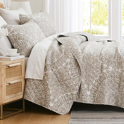 Bed with paisley patterned bedding in a bright bedroom