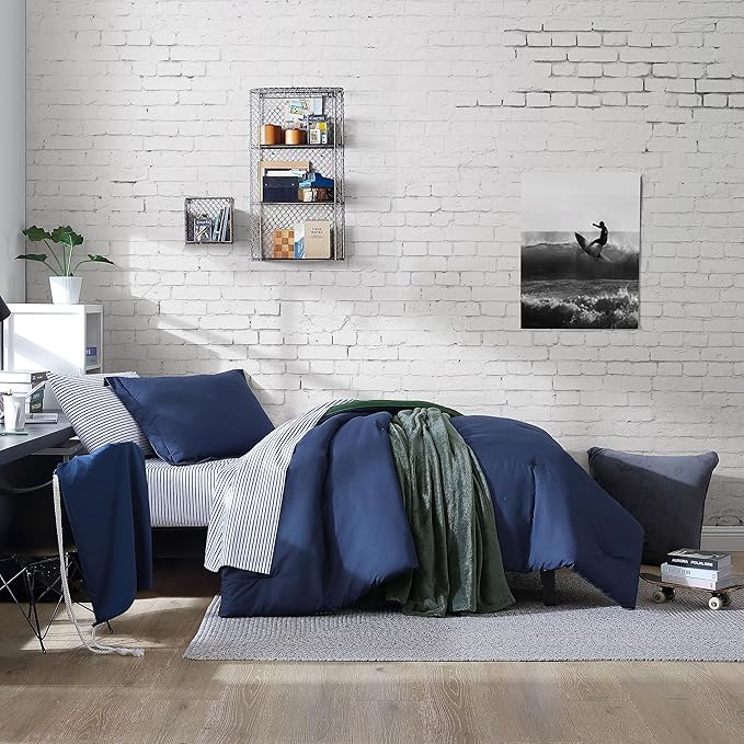 Modern bedroom with white brick wall, bed with blue bedding, and decorative items.